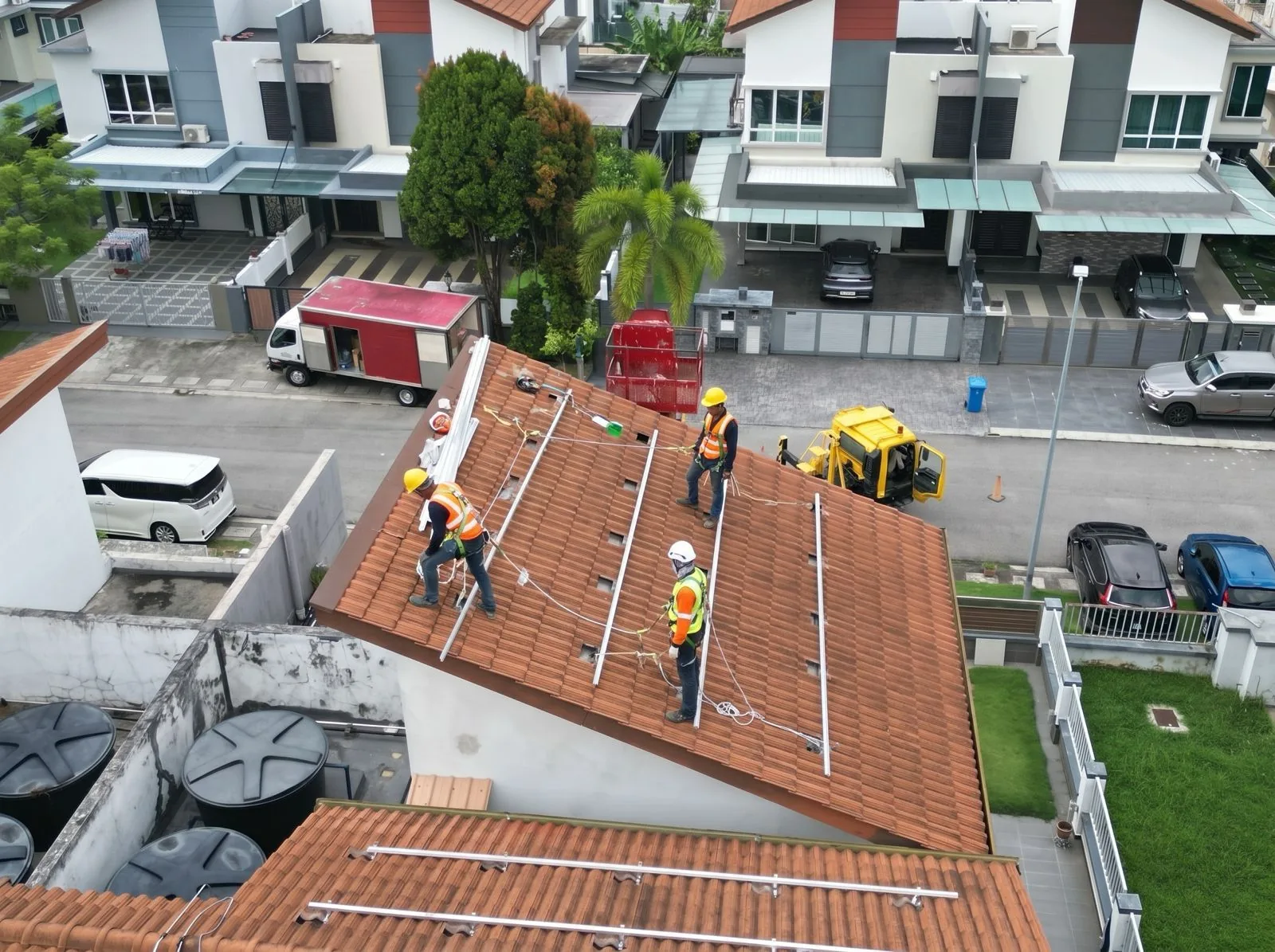 Pekerja pemasangan solar menyelaraskan rel di bumbung kediaman